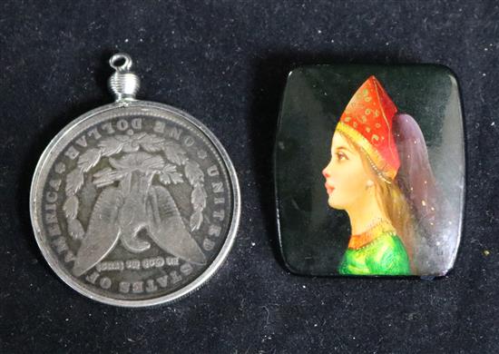 A USSR brooch and a mounted 1886 US one dollar.